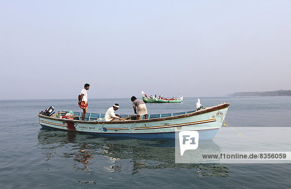 Einheimische Muschelfischer in ihrem Boot vor der Küste  Varkala  Kerala  Indien