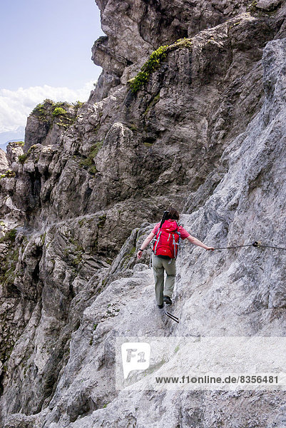 Eine Wanderin auf dem versicherten Jubiläumssteig  einem Teilstück auf dem Wilder-Kaiser-Steig  Kaisergebirge  bei Ellmau  Tirol  Österreich