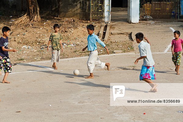 Boys playing football at street  Rangun  Myanmar  Asia