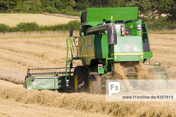 Combine harvester at work in wheat field near Shipton-under-Wychwood