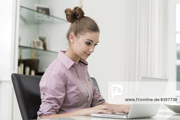 Portrait of teenage girl using laptop