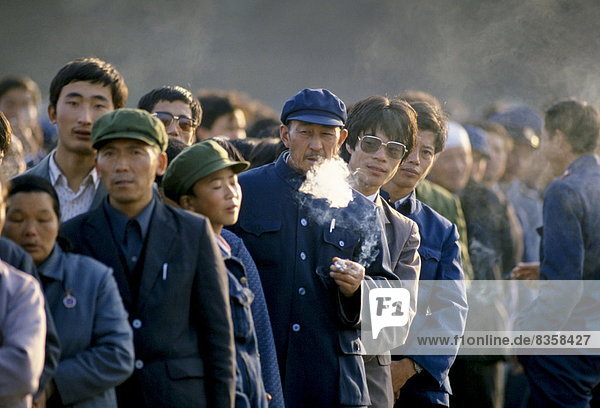 Chinese people  some smoking cigarettes  in Tiananmen Square in Peking  now Beijing  China in the 1980s