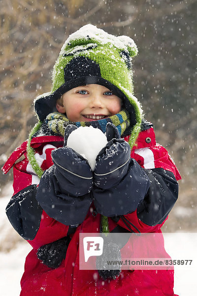 Kleiner Junge mit Schneeball.