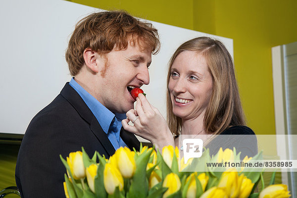 Frau füttert Mann mit Erdbeere