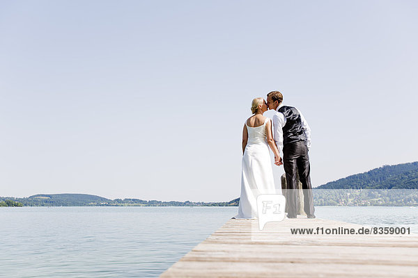 Germany  Bavaria  Tegernsee  Wedding couple standing on jetty