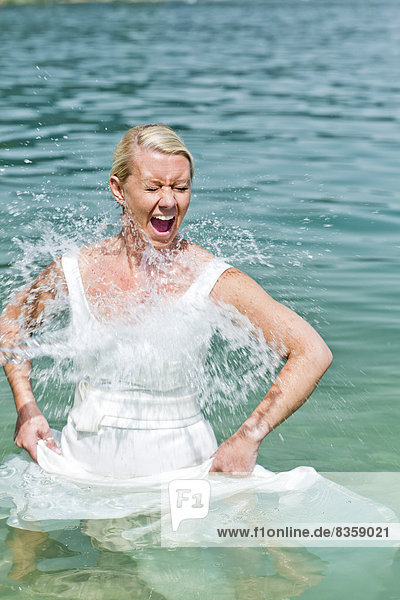 Germany  Bavaria  Tegernsee  Wet bride in lake  laughing
