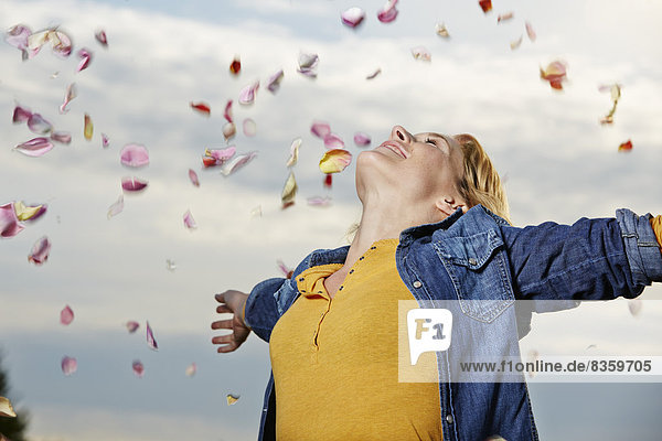 Young c  Young woman throwing petals