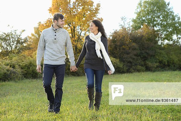 Lächelndes Paar geht im Herbst spazieren