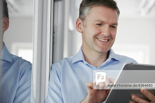 Mann mit digitalem Tablett im Büro