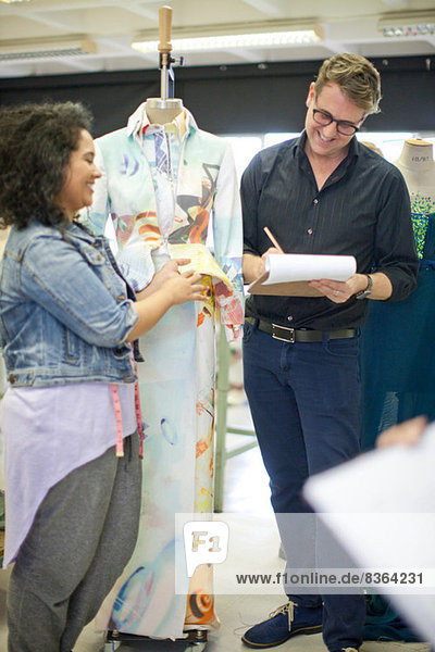 Fashion design teacher assessing student