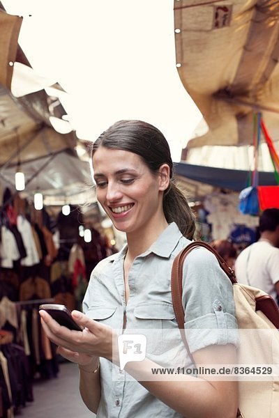 Junge Frau SMS am Handy  San Lorenzo Markt  Florenz  Toskana  Italien
