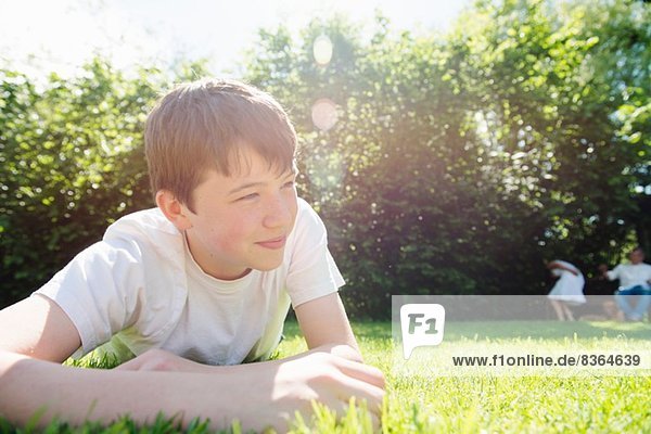 Portrait of teenage boy lying on grass looking away