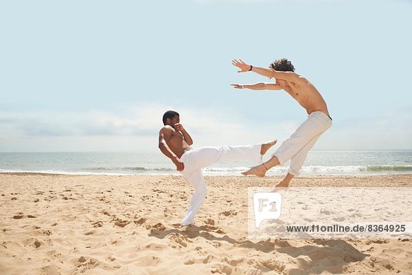 Männer beim Capoeira am Strand