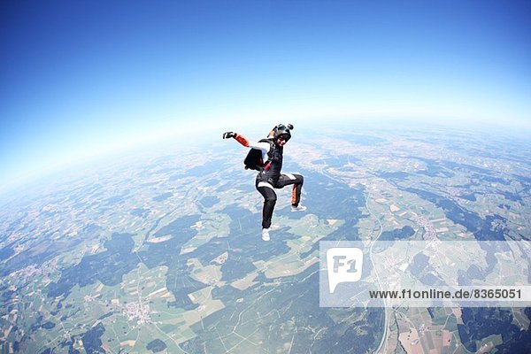 Fallschirmspringerin frei fallend über Leutkirch,  Bayern,  Deutschland
