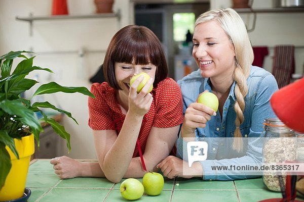 Freundinnen in der Küche mit Äpfeln