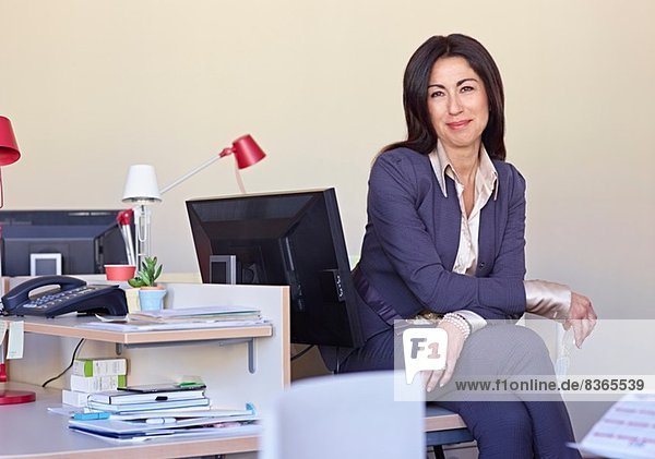 Businesswoman wearing suit sitting at desk