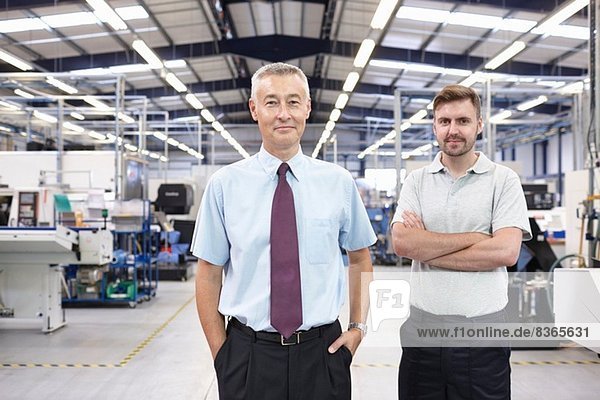 Portrait of manager and co-worker in engineering factory