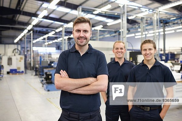 Portrait of three workers in engineering factory