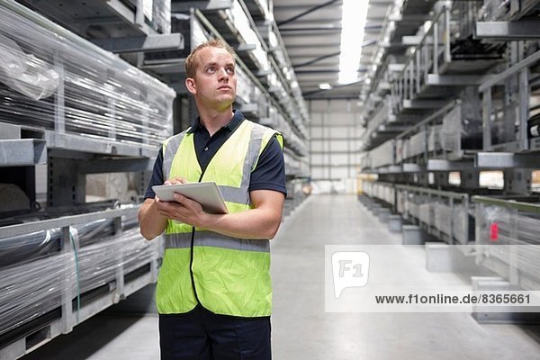 Worker checking order in engineering warehouse