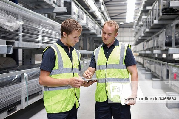 Workers checking orders in engineering warehouse