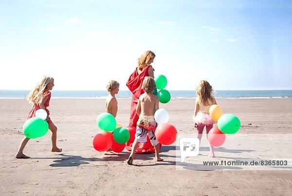 Mutter mit vier Kindern am Strand mit Ballons  Wales  UK