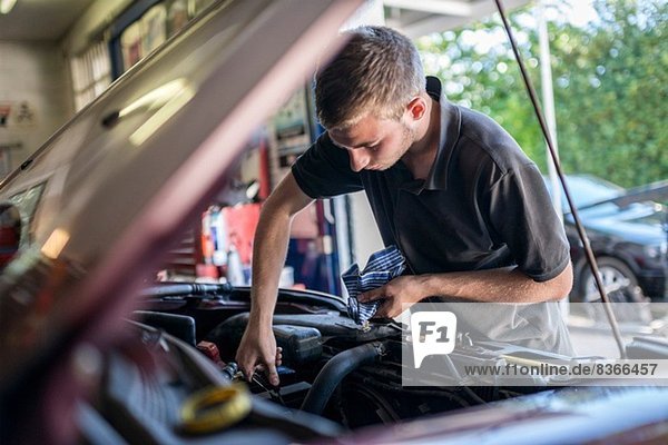 Mechanic working on car with bonnet open