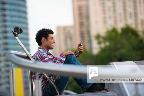 Man smiling at text message on mobile phone