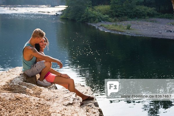 Young couple sitting on rock ledge  Hamburg  Pennsylvania  USA