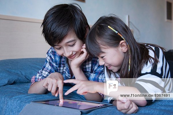 Bruder und Schwester mit digitaler Tablette