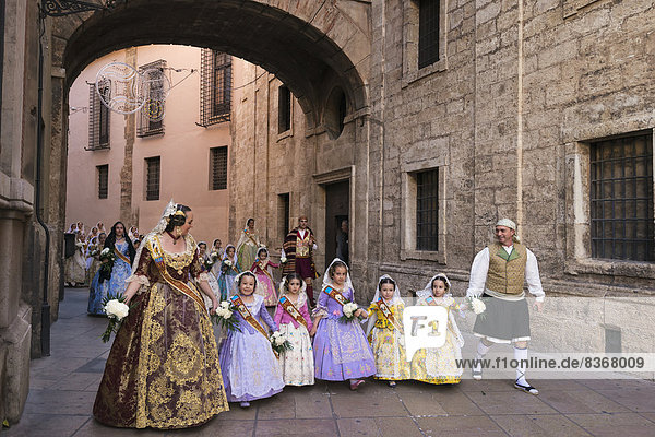 People Dressed Up In Traditional Casal Faller Outfits In Procession With Flower Offering For Virgin De Los Desamparados At Fallas Festival Valencia  Spain