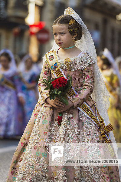 Young Girl Dressed Up In Traditional Casal Faller Dress In Procession With Flower Offering For Virgin De Los Desamparados At Fallas Festival Valencia  Spain
