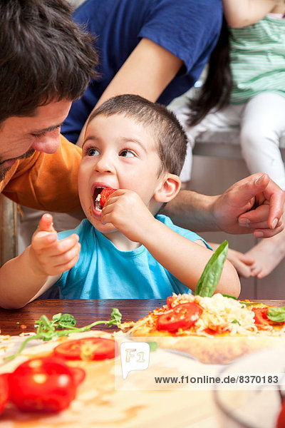 Boy eating homemade pizza toppings