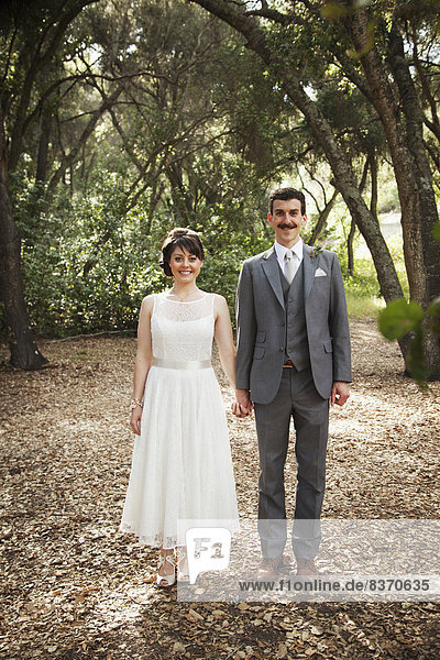 Portrait Of A Couple Standing In A Park In Formalwear California  United States Of America