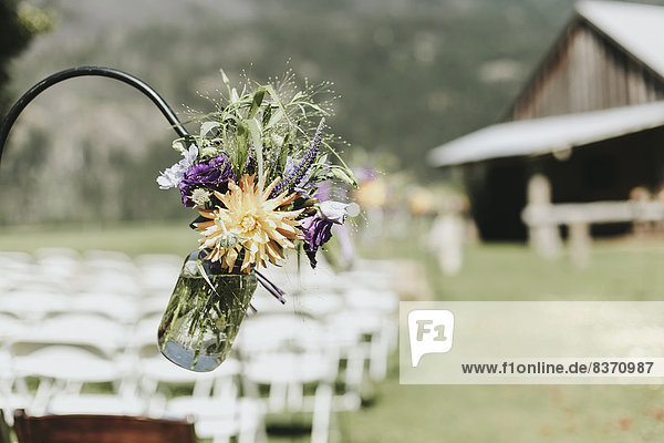 A Jar Of Wildflowers Hanging For Decoration At An Outdoor Wedding Ceremony Pemberton  British Columbia  Canada