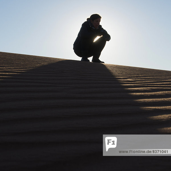 hocken - Mensch  Frau  hoch  oben  Sand  Düne  Marokko