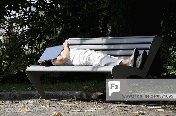 A Woman Sleeping On A Park Bench With A Book Over Her Face Locarno  Ticino  Switzerland
