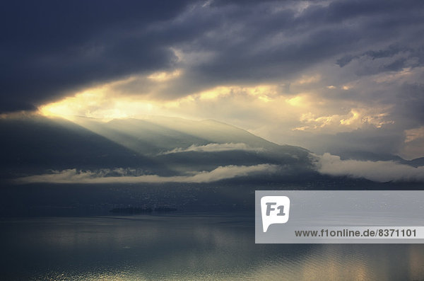 The Sun Shining Through Storm Clouds Over Water Isole Di Brissago  Ticino  Switzerland
