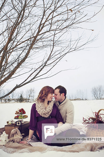 A Husband And Wife Sitting In An Embrace While Having A Winter Picnic Edmonton  Alberta  Canada