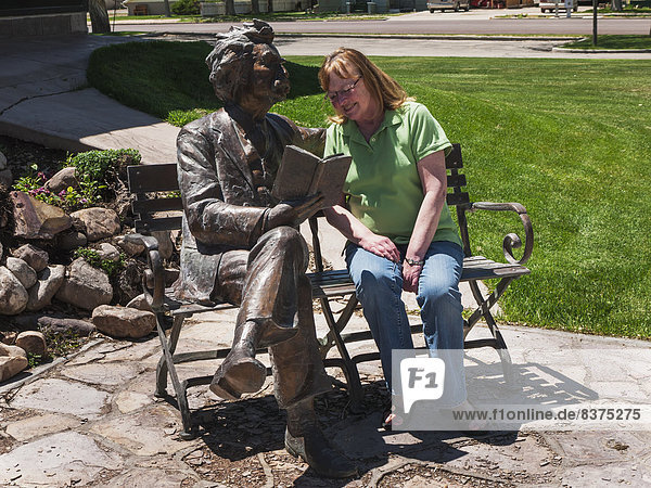 Vereinigte Staaten von Amerika  USA  Außenaufnahme  Frau  sitzend  Markierung  Statue  Sitzbank  Bank  Bibliotheksgebäude  Flussdelta  Delta  Utah
