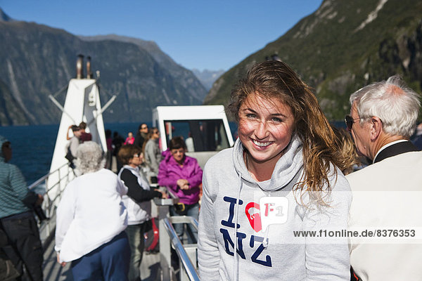 A Young Woman Poses With An I Love New Zealand Sweatshirt On A Boat Cruise In Milford Sound  New Zealand