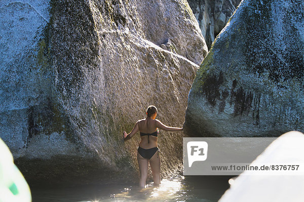 A Girl Wades In The Water At Split Apple Rock In The Abel Tasman National Park  New Zealand