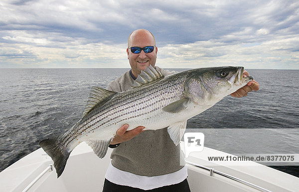 Man In A Boat Proudly Holding A Large Fish  Usa