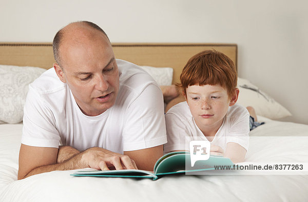 Father Reading To His Son On A Bed  San Francisco  California  Canada