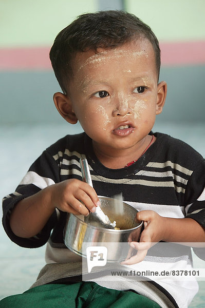 A Child Eating In Preschool Centre Myanmar