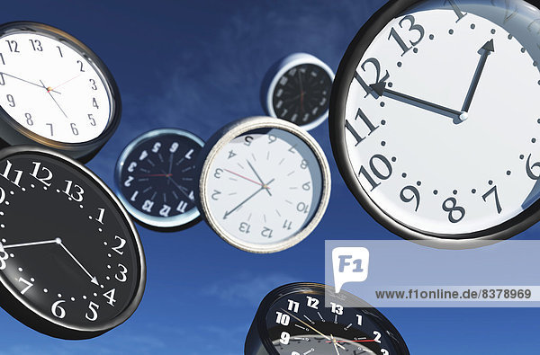 Verschiedene fliegende Uhren mit unterschiedlichen Zeiten