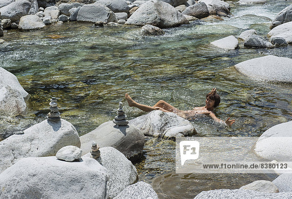 Woman bathing in the mountain river of Maggia  Val Lavizzara valley  Canton of Ticino  Switzerland