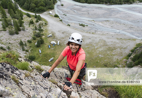 Female mountain climber climbing a fixed rope climbing route  Vallée de la Romanche valley  Villar-d'Arêne  Provence-Alpes-Cote d'Azur  France