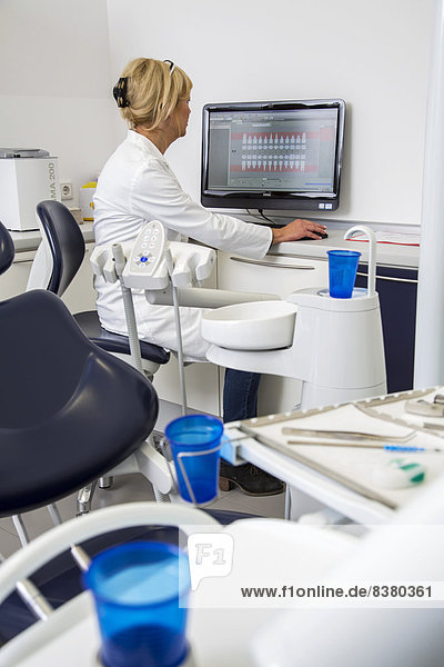 Zahnarzthelferin trägt die Daten eines Patienten in die elektronische Krankenakte ein  Deutschland