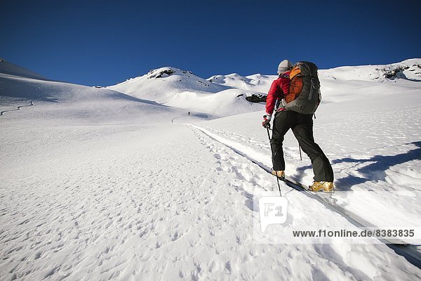 A ski tourer skinning towards a snowy peak in France.