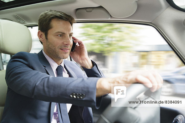 Businessman talking on cell phone while driving